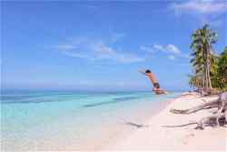 Traveller jumping on beach at Palawan, Philippines