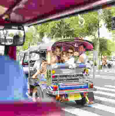 Travellers riding in a tuk tuk in Bangkok.
