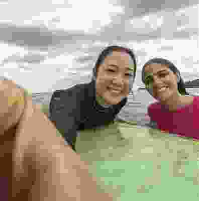 Two women taking selfie on a surfboard in Playa Carrillo. 