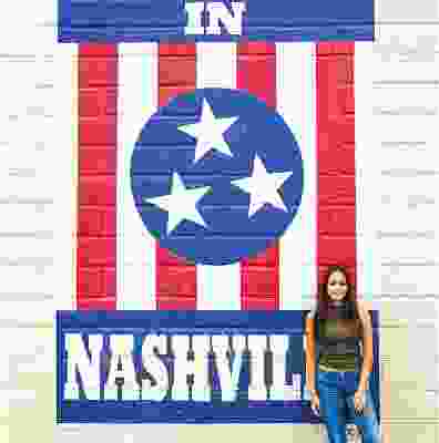 Women traveller posing in front of American style flag in Nashville.