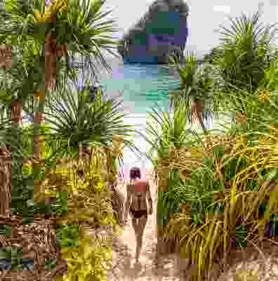Women traveller walking onto Phi Phi beach.