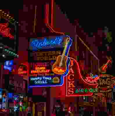 Lit up street of western style bars in Nashville at night.