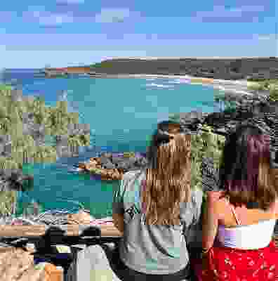 Two girl travellers sat overlooking Cairns beach.