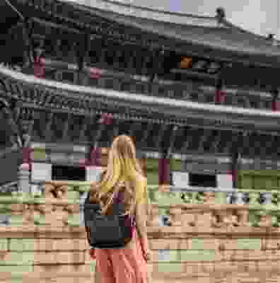 Blonde traveller looking at the Gyeongbokgung palace, Seoul. 