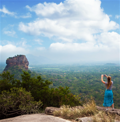 Women traveller taking photo on top of the Sigiriya rock viewpoint.