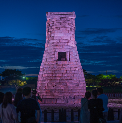 The Cheomseongdae observatory lit up pink at night in Gyeongju.