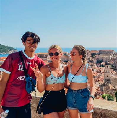 Travellers posing in front of a panoramic view of Dubrovnik.