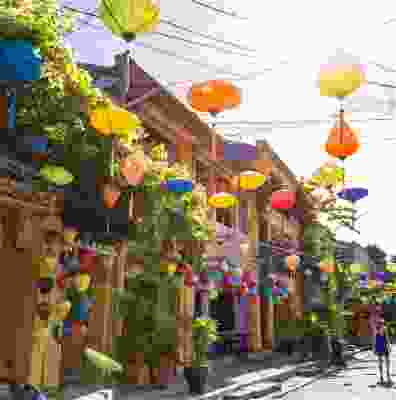 Women walking down a street full of lanterns in Hoi An.