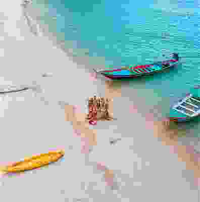 Group of travellers posing on the beach of Koh Phangan.