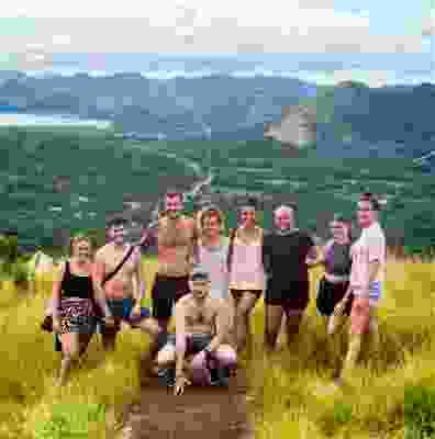 Group of travellers smiling on top of the Coron viewpoint.