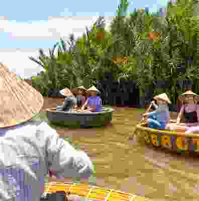 Travellers taking part in crab fishing in boats wearing traditional Vietnamese hats.