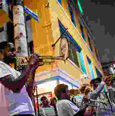 Group of locals playing in a band of trumpets in the street at night.