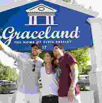 Three travellers taking a selfie in front of the Graceland sign in Memphis.