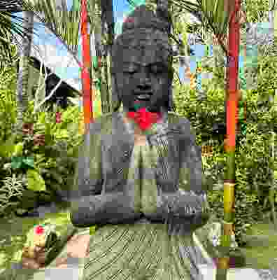 A flower placed in buddha stone structure's hand in Ubud.