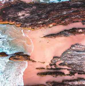Aerial view of waves crashing against rocks and the shore